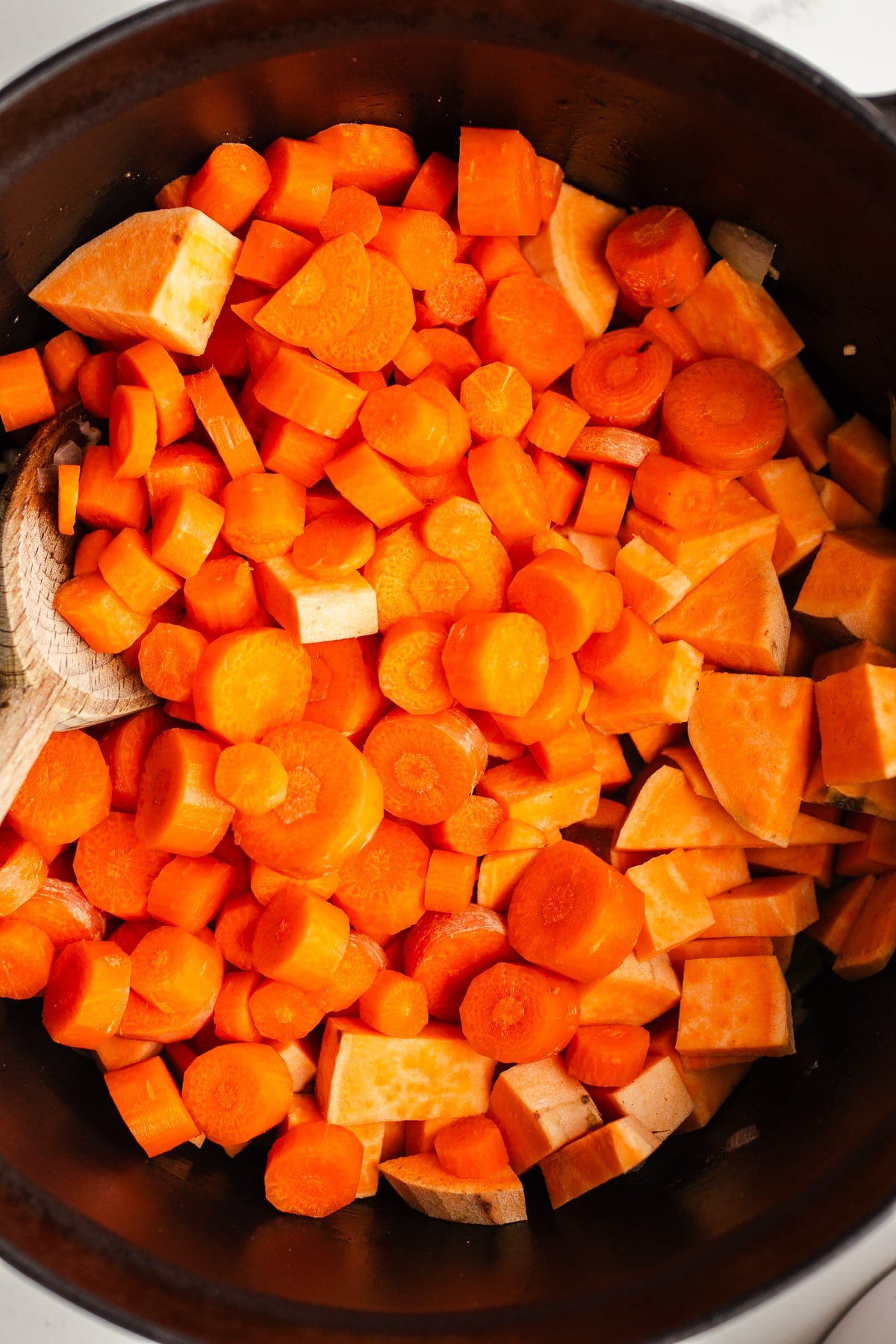 Raw carrots and sweet potato in a pot.