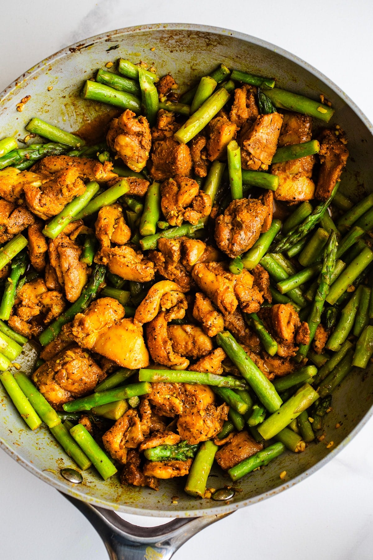 Asparagus and chicken in a pan.