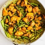 Chicken and asparagus in a pan.