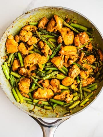 Chicken and asparagus in a pan.