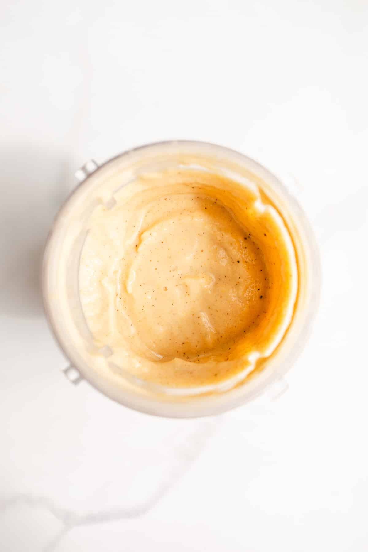A peach smoothie blended in a cup.