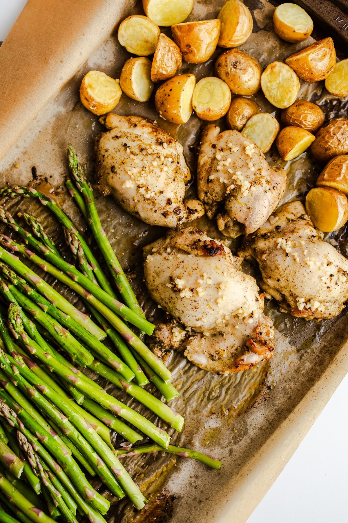 Potatoes, chicken, and asparagus on a sheet pan.