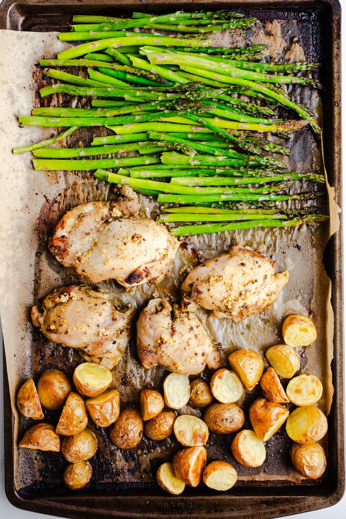 Asparagus, chicken, and potatoes on a sheet pan.