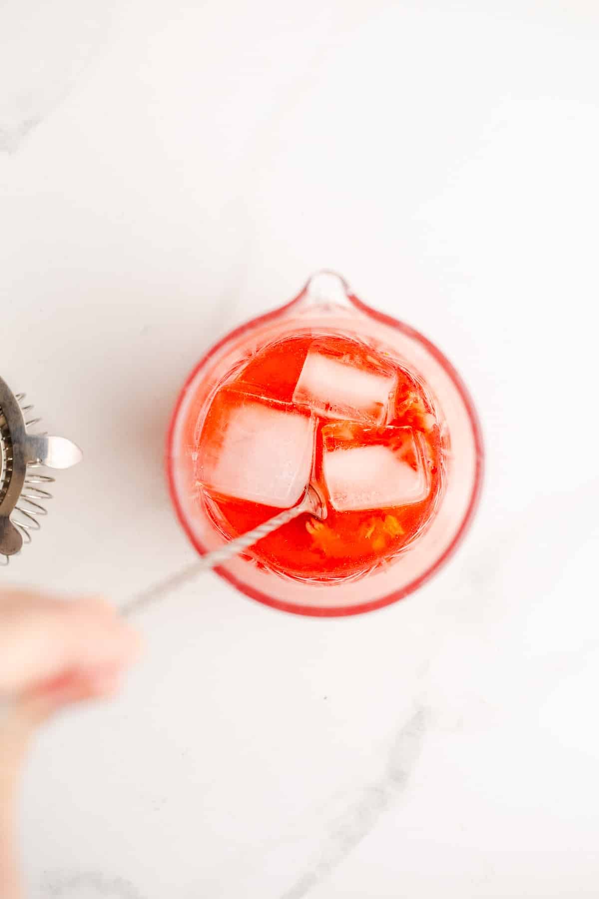 Stirring cocktail in glass.