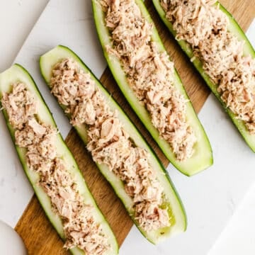 Tunafish in cucumber boats on a serving board.
