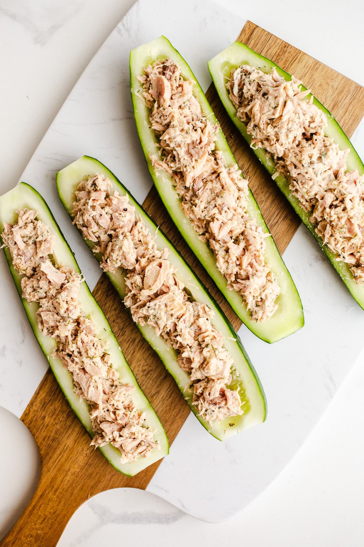 Tunafish in cucumber boats on a serving board.