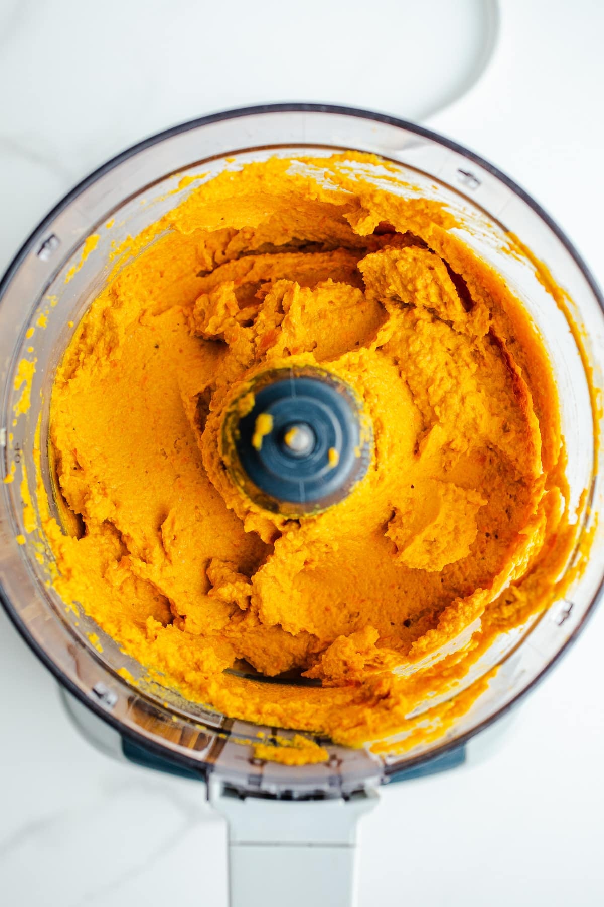 Smooth carrot hummus in a food processor.