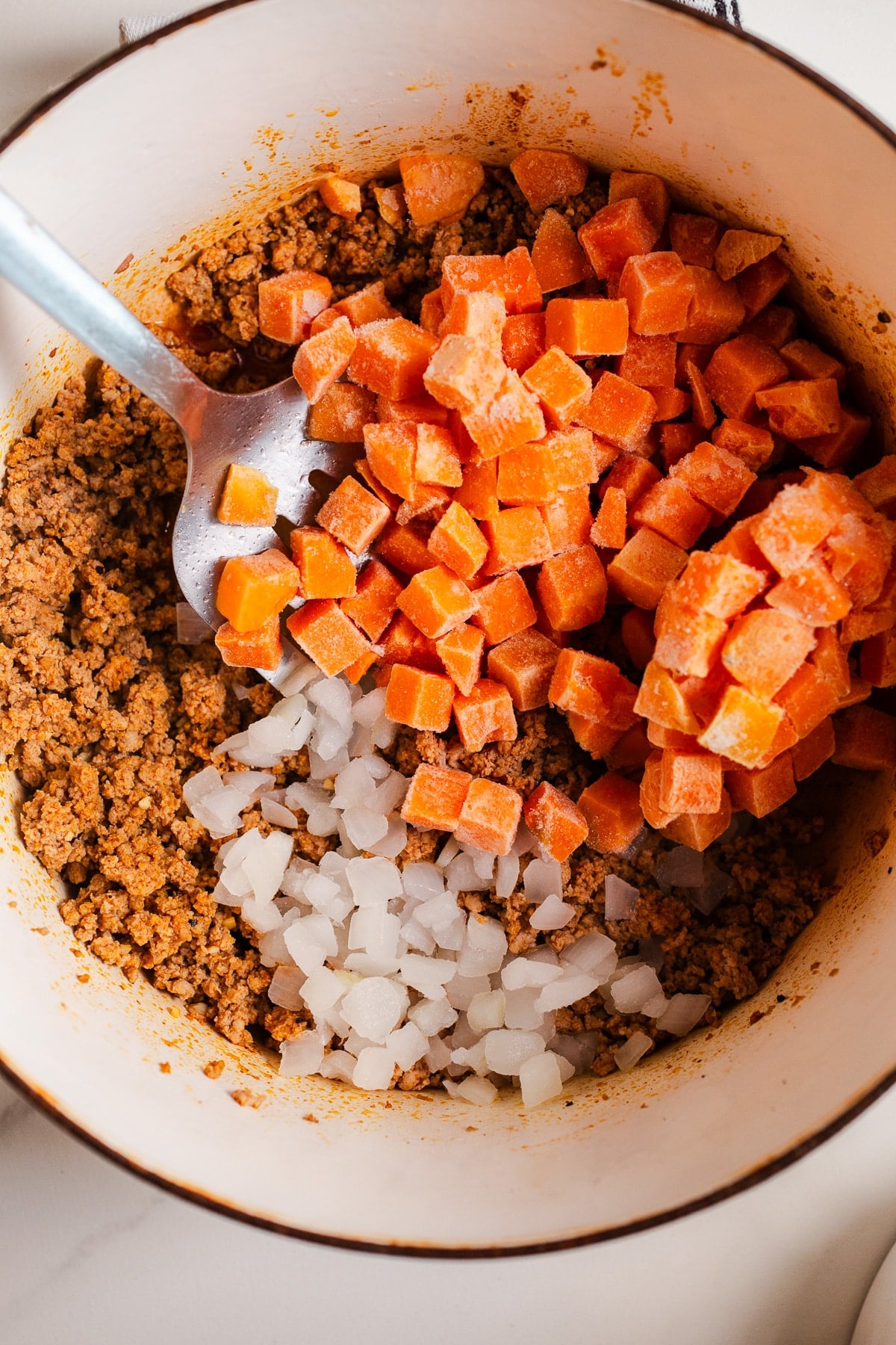 Turkey and frozen sweet potatoes in a large pot.