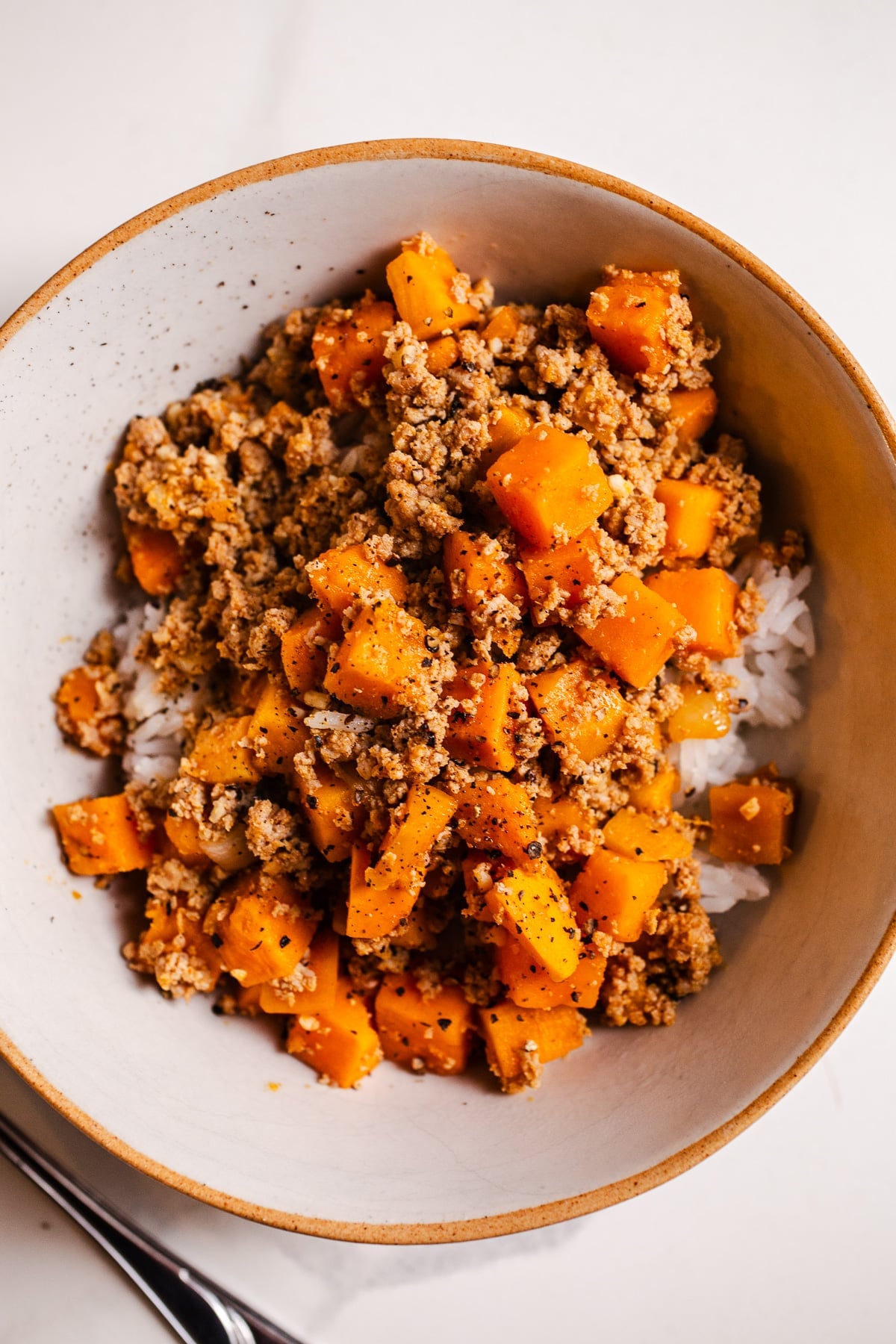 Turkey sweet potato skillet over rice in a bowl.