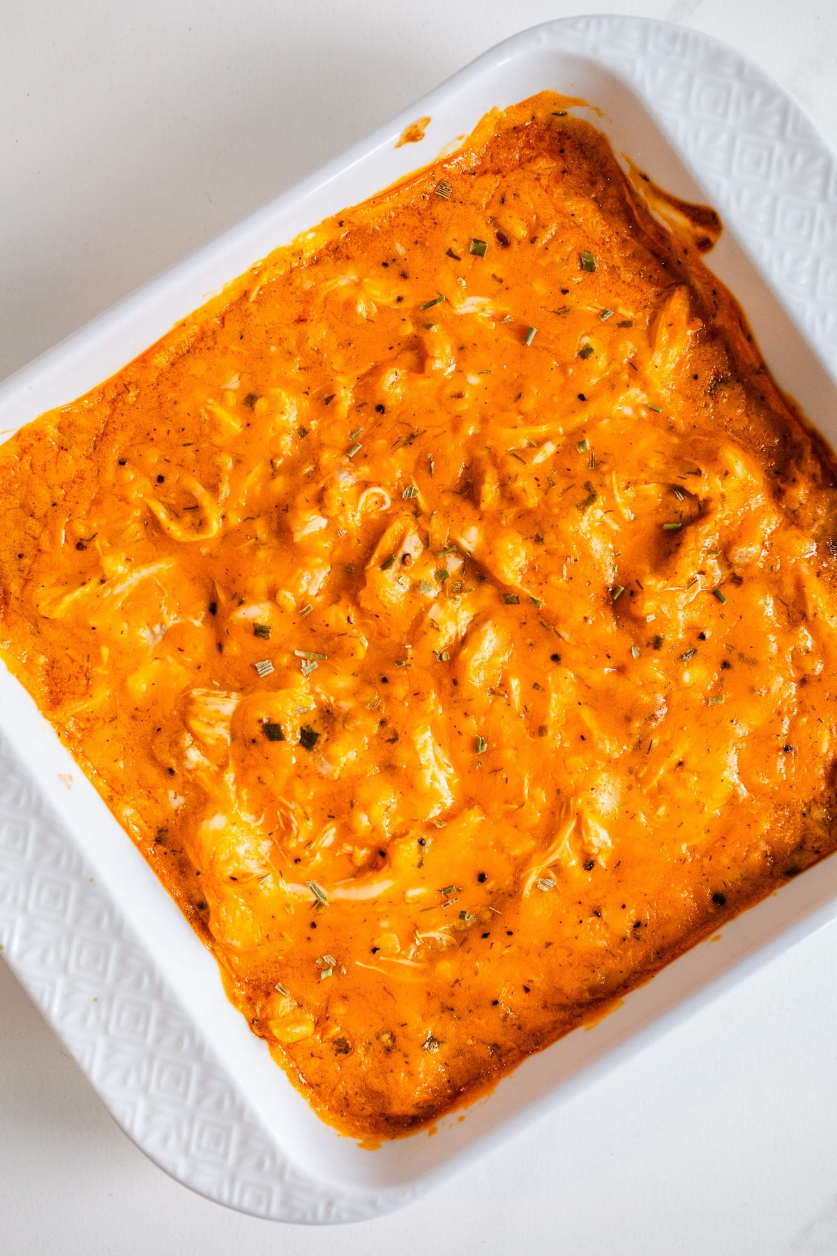 Buffalo chicken dip in a white baking dish.