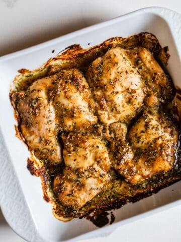 Baked maple dijon chicken in a white dish.